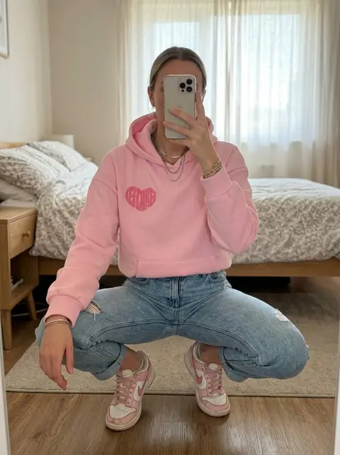 The same pink heart-logo hoodie, shown on a model