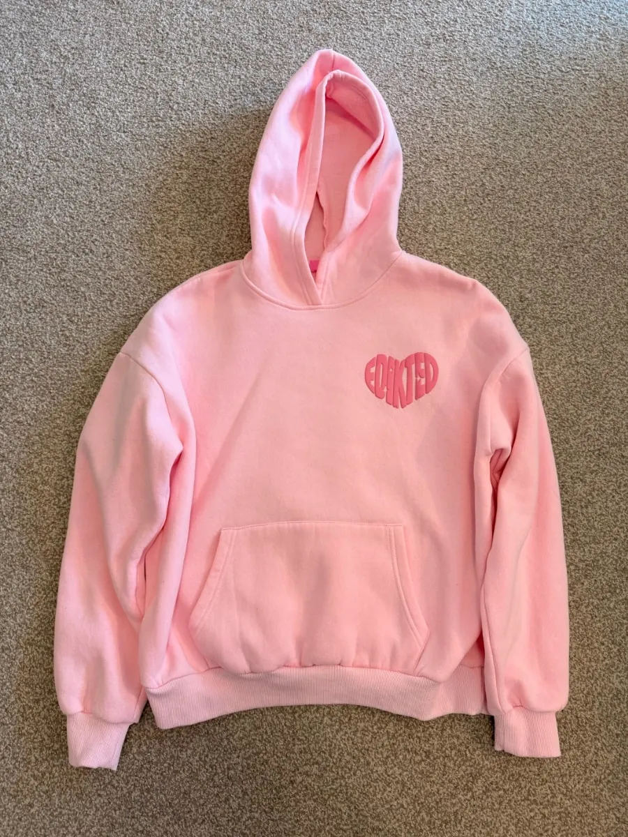 A good listing photo: a pink hoodie laid flat in bright, even light on a clean background